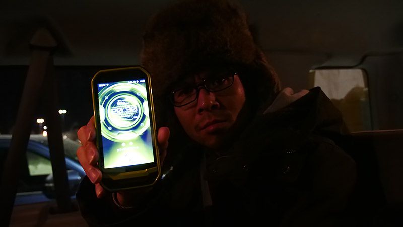 クルマの中でTORQUE G03をカメラに見せる地主
