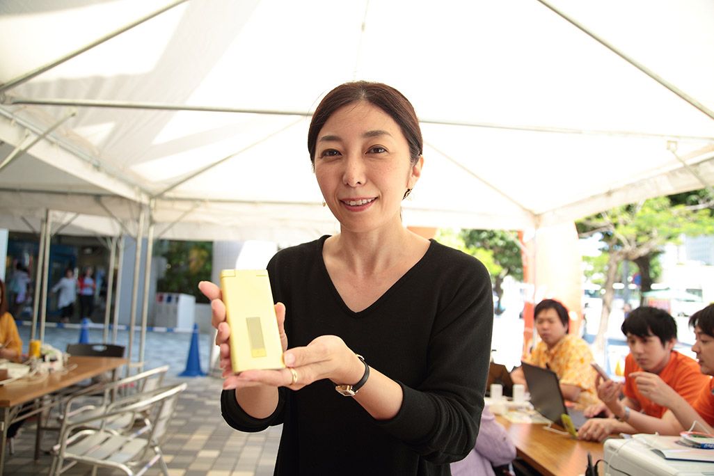 ガラケーを手に微笑む女性