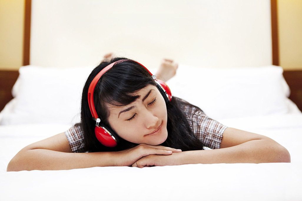 ベッドで音楽を聴いている人