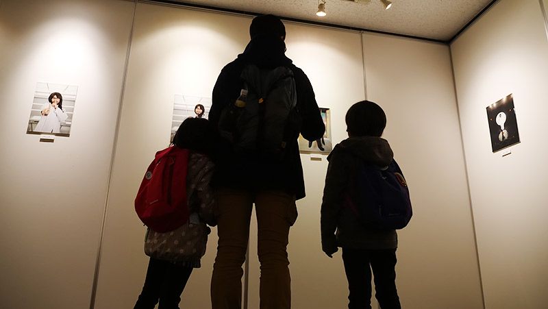 写真を見つめる親子3名