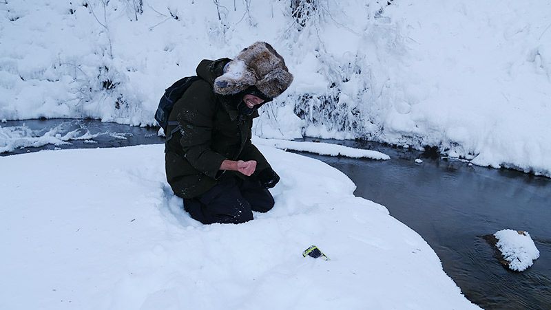 雪原でしゃがみ込み手をおさえて痛がる地主