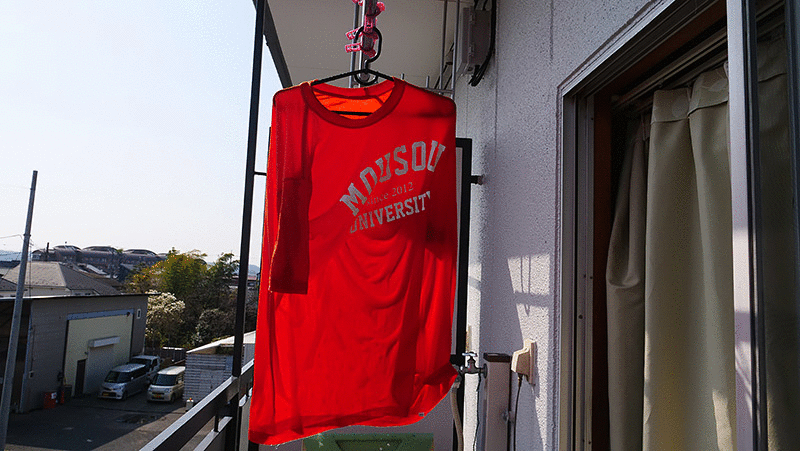 水分を多く含んだまま干されるオレンジのTシャツ