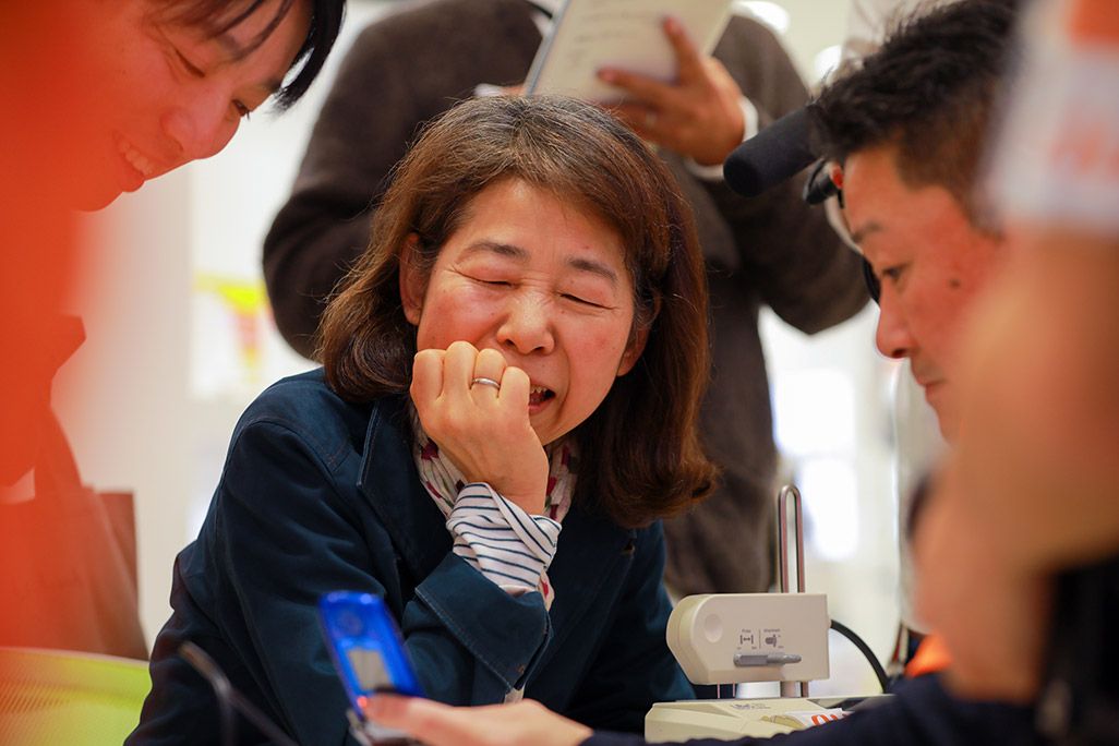 再起動された娘さんのケータイを見つめる女性