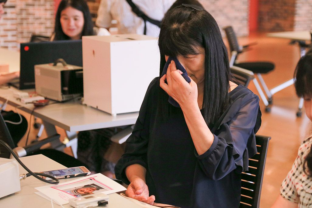 「おもいでケータイ再起動」の会場で涙ぐむ女性