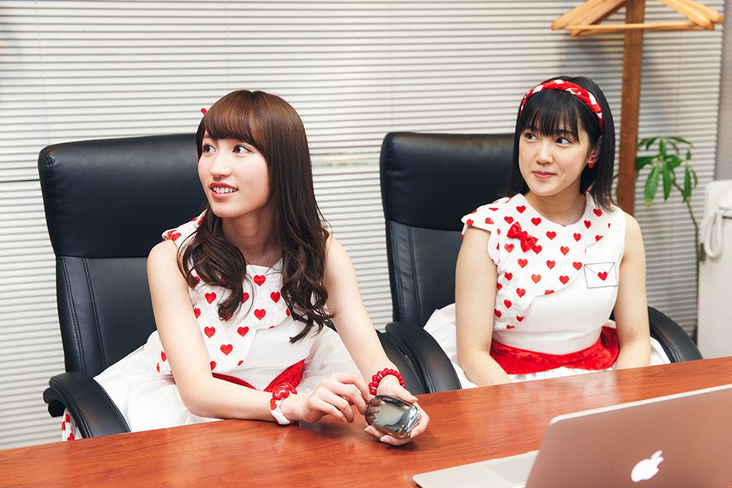 PCで「ケータイ図鑑」ウェブサイトをチラ見してからインタビューに答えるカントリー・ガールズ山木梨沙と、小関舞