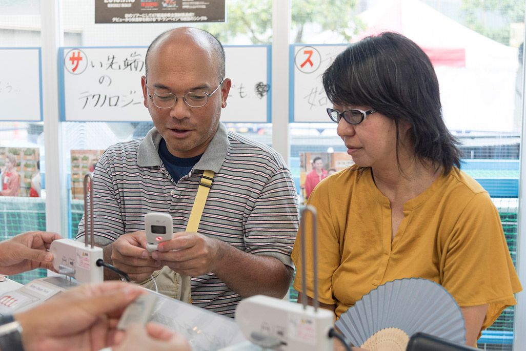 再起動したケータイを手に感慨深げな夫婦