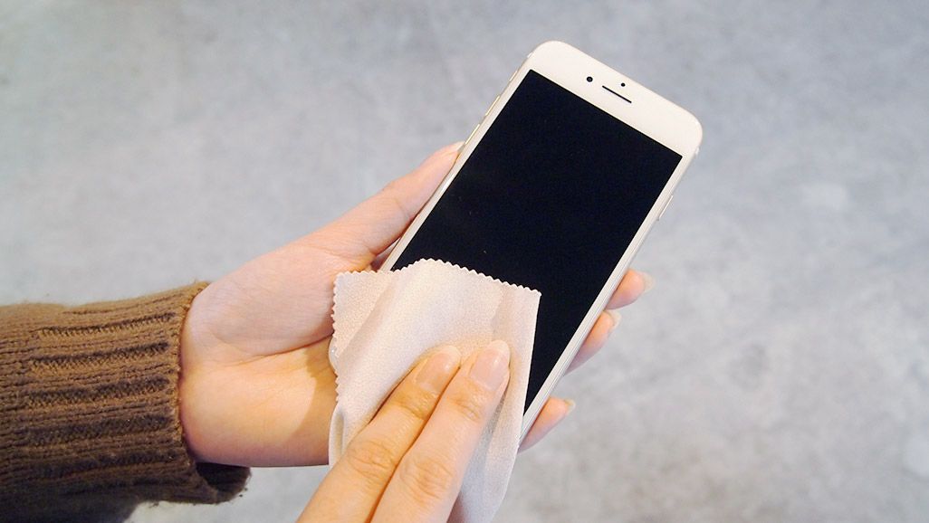 iPhone 7のホームボタンをクロスで拭いている
