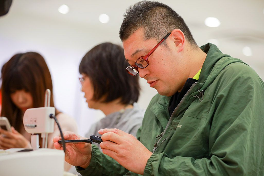au 昔、使っていたケータイを見つめる男性