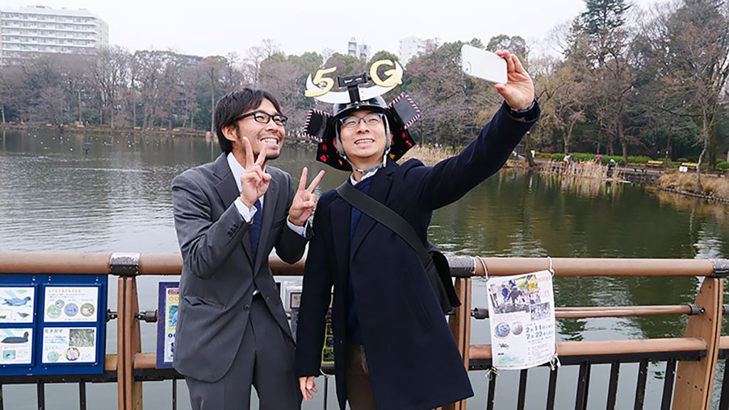 兜をかぶったAさんと記念撮影をする地主