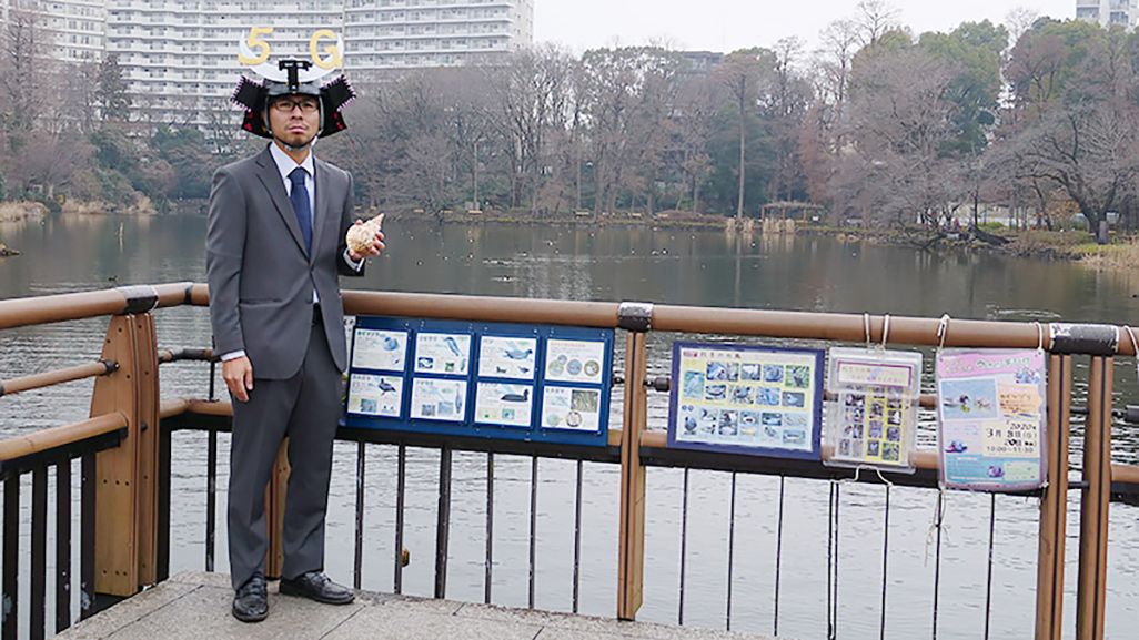 水辺でスーツを着て兜をかぶった地主