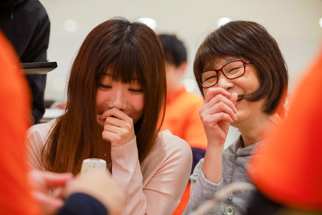 au 昔のケータイを見ながら笑う女性の親子