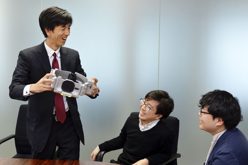 完成したTORQUEベルトを手にする開発者チーム