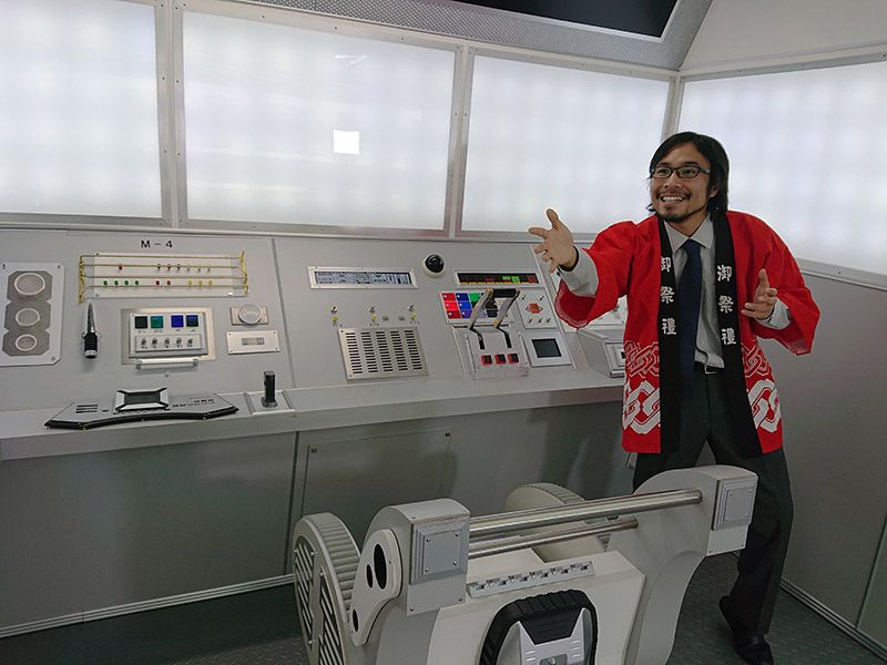 宇宙船を模したスタジオ内でハッピでポーズをとる地主